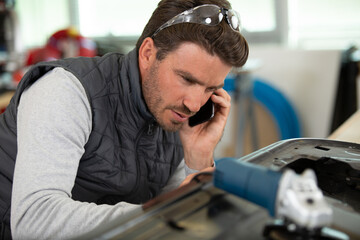 man mechanic on the phone