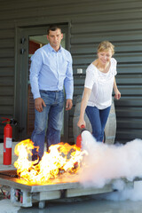 Fototapeta premium woman demonstrating how to use a fire extinguisher
