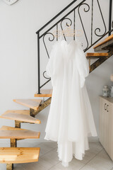 white wedding dress hanging in the interior