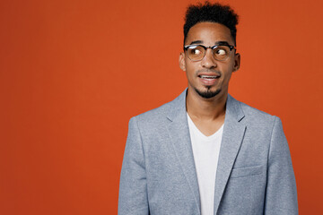 Young successful employee business man corporate lawyer wear classic formal grey suit shirt glasses work in office look aside on workspace area mock up isolated on plain red orange background studio.