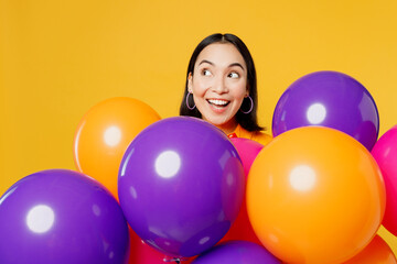 Fototapeta na wymiar Happy fun amazed surprised shocked impressed young woman wearing casual clothes celebrating near balloons look aside on area isolated on plain yellow background. Birthday 8 14 holiday party concept.