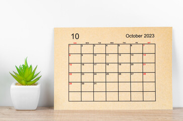 The October 2023 Monthly calendar for 2023 year on wooden table.