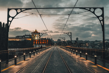Fototapeta premium Porto, Portugal - 2023: Upper level of Dom Luis Bridge, a landmark in Oporto Portugal with a metro railway seen from the middle early in the morning. Miradouro da Serra do Pilar in the far left.