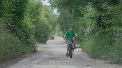 One child riding a bike on rural road, freedom play, active outdoor