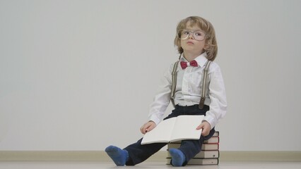 Little boy with eyeglasses finished reading the book