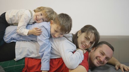 Happy family stack, kids and parents lying one on top of another