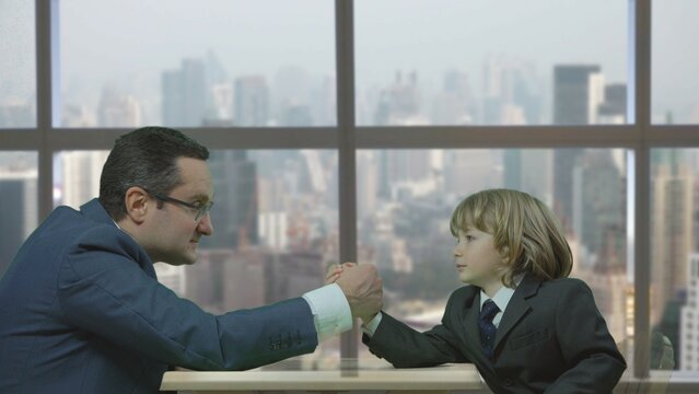 Man And Kid Arm Wrestling At The Office