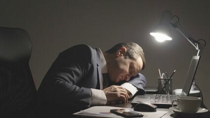 Man tired at work on laptop late in the night