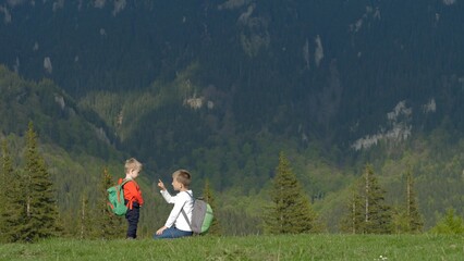 Fototapeta premium Kids with backpacks on the mountain