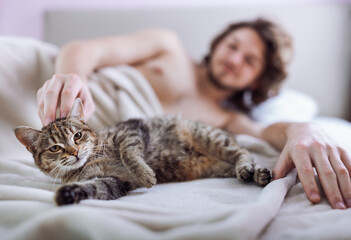 Man with kitten in bed