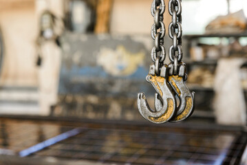 Metal old crane hook on steel chain slings.