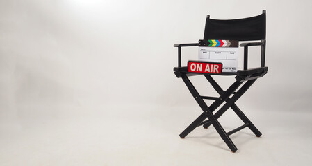 Black director chair and clapper board and on air box on the chair on white background