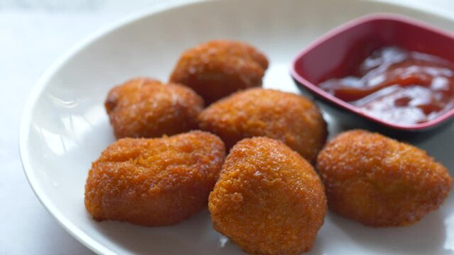 close up of chicken nugget and sauce on table 