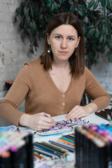 Fototapeta premium girl sitting at the table and drawing