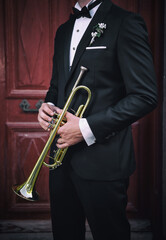 Man in suit holding trumpet instrument