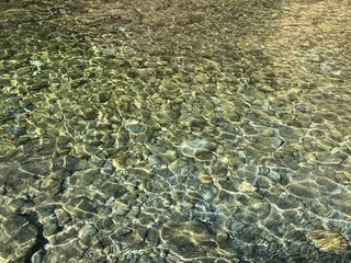 Pebbles in clear transparent sea water.