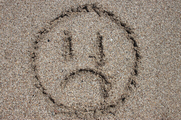 Fototapeta na wymiar sad emoticon on beach sand