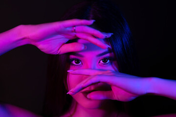 Young asian woman portrait in red-blue neon lights.