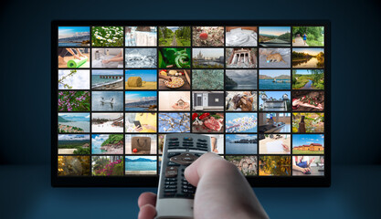 Multimedia Television video streaming, Media TV on demand. Subscription Streaming video. Internet streaming service concept. Man hand holding TV remote control.