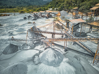 Stone crusher machine system at open pit mining quarry. Aerial drone shot