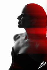 Beautiful and sexy woman silhouette with black corset and wet hair in bright glowing studio background in red color split effect. Model standing in grace pose. Futuristic looking style