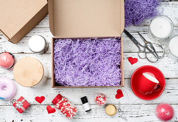 Seasonal opened gift box for valentine day with candle, red cup and heart shape sweets