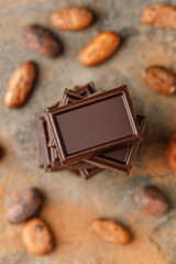 Broken chocolate pieces on dark background. Stack of dark chocolate. Chocolate concept