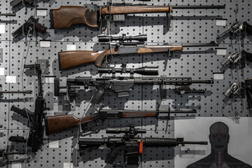 Collection of rifles and carbines. Various firearms hang on special mounts on the wall. Weapon back.