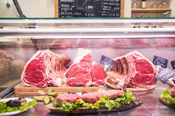 Fiorentine beef steak - Butcher's shop selling raw meat at traditional italian market stall 