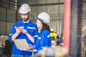 Engineers team mechanic using computer controller Robotic arm for welding steel in steel factory...