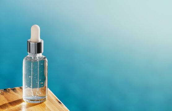 One Mockup Transparent Glass Bottle On Wooden Deck Over Blue Water. Cosmetics Collagen Serum, Organic Essential Or Aroma Oil For Beauty Skin Care. Summer Hydrating And Vitalizing Essentials