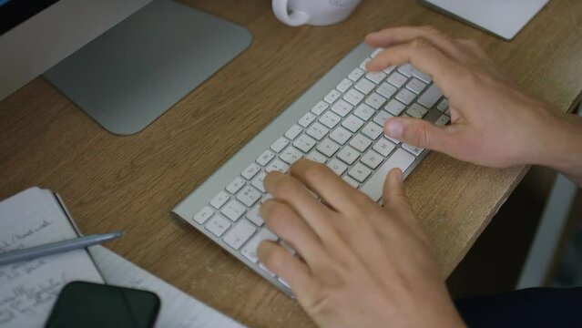 Hands of a man typing on a computer keyboard