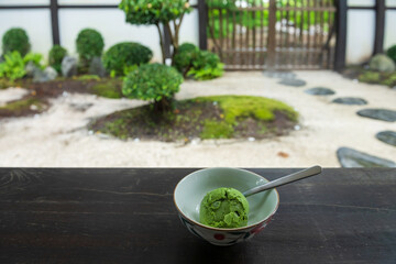 Matcha green tea ice cream on wooden table at Japanese garden