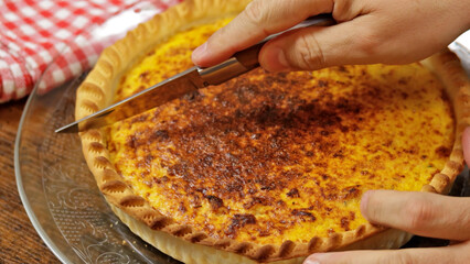 personne qui coupe une quiche 