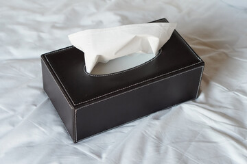white tissues in a rectangular black leather box placed on bedding background, object, decor, modern, copy space