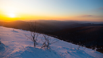 panorama of snow-capped mountains at sunset during a cold winter  mighty mountain peaks in the Polish Bieszczady mountains  mountain vegetation covered with snow © Lens Down Under