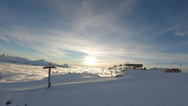 A Snake Gliss toboggan train descends the slopes at sunset in a magical atmosphere