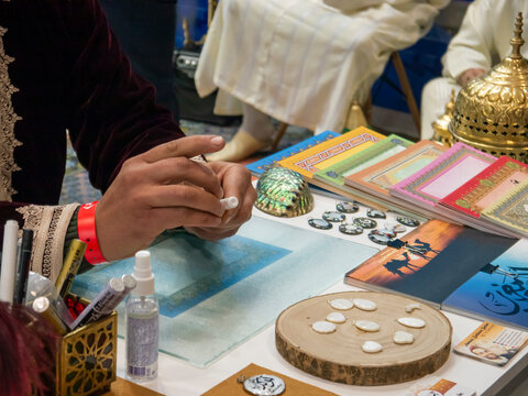 Close up of the hands of a Moroccan artisan preparing material for handicrafts in FITUR 2022