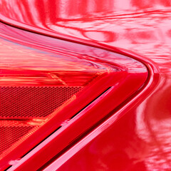 Details of the geometric shape of the signalman of a red car and its reflections