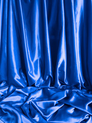 Royal blue textile background. Elegant smooth blue satin fabric. Silk fabric drapes. Luxurious...