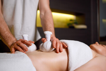Obraz na płótnie Canvas Abdominal massage with warm pindas at spa center
