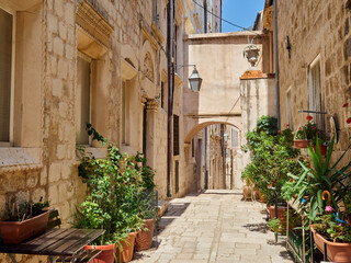 Traditional alley with stone  houses and an archway in Dubrovnik Old Town in summer. Croatia, Europe