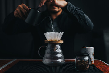 Professional barista making filtered drip coffee in coffee shop. Close up of hands barista brewing...