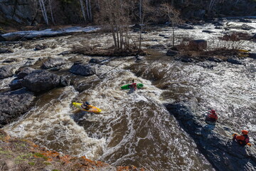 Water sports competitions on kayaks on a full-flowing river in spring