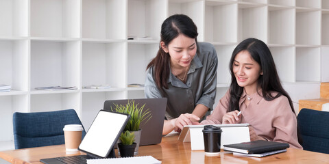 Two young Asian business woman talk, consult, discuss working with new startup project idea...
