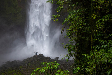 girl standing in front of san fernando waterfall in costa rica; huge waterfall in the middle of tropical rainforest; highest waterfall in costa rica, hidden gems of costa rica