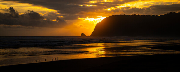 Obraz premium panorama of paradise Costa Rica beach at sunset; colorful sunset on tropical san miguel beach over the pacific