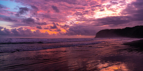 panorama of paradise Costa Rica beach at sunset; colorful sunset on tropical san miguel beach over...