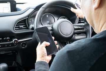 運転席でスマホを使う男性