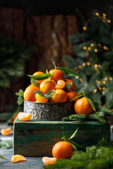 Christmas tangerines in metal box with christmas decorations on dark background. Christmas concept 